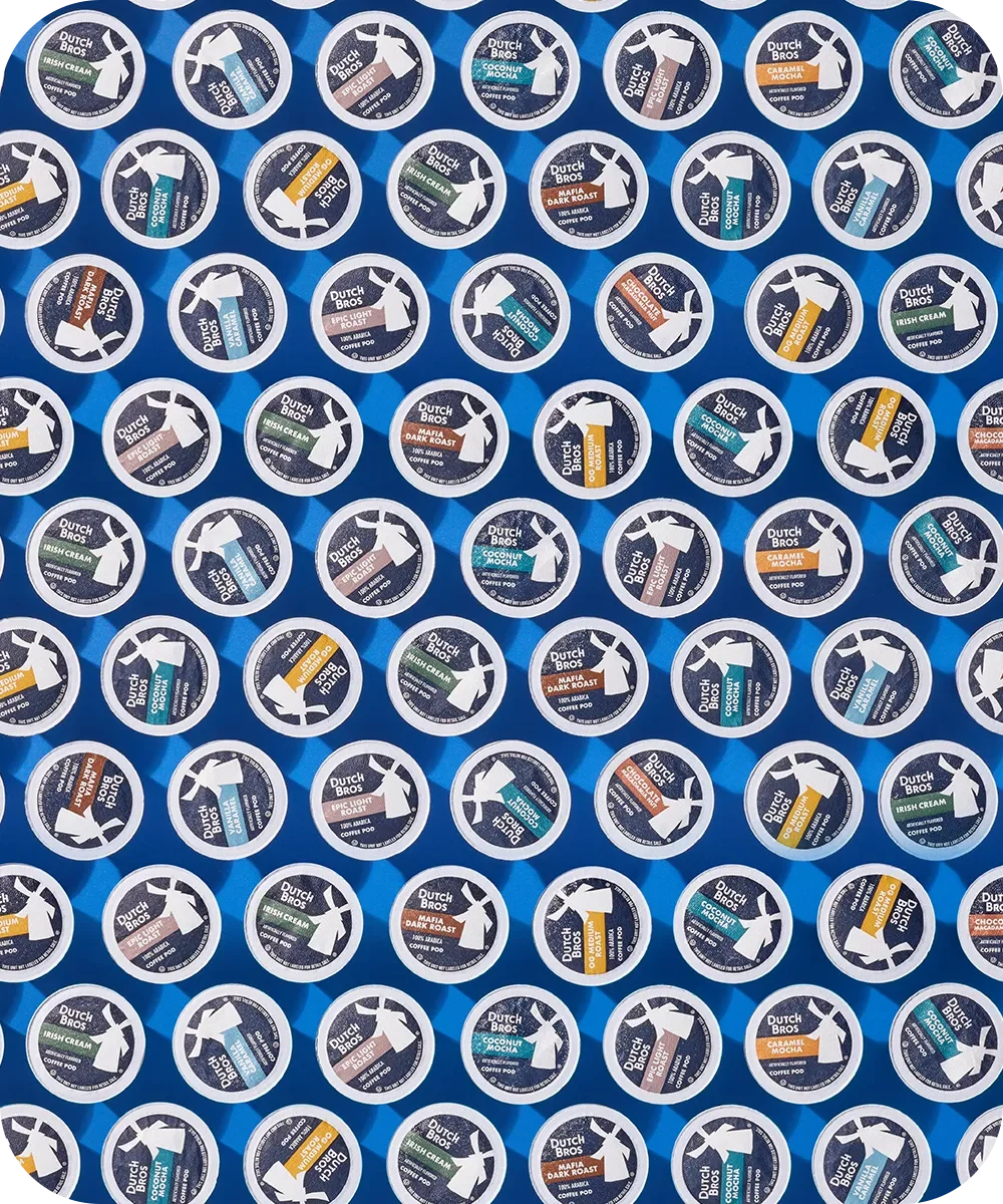 Rows of Dutch Bros coffee pods in various flavors including Irish Cream, Coconut, and Dark Roast against a blue background.