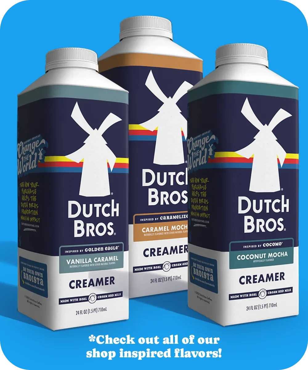 Three Dutch Bros coffee creamers in different flavors: Vanilla Caramel, Caramel Mocha, and Coconut Mocha against a blue background.